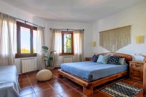 圣安东尼奥湾Authentic 4BR Pool & Sauna Villa, Sant Agusti的一间卧室配有一张带蓝色棉被的床