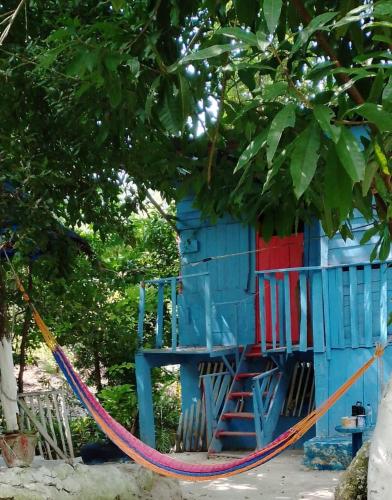 埃尔莱马特Hospedaje y jardin botanico chiltun maya的一座五彩缤纷的树屋,四周有绳子