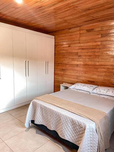 本图贡萨尔维斯Vale dos Imigrantes的一间卧室配有一张床和白色橱柜