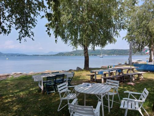 多尔梅莱托Bnbook Lago Maggiore Studio 2的一组桌子和椅子,靠近湖边