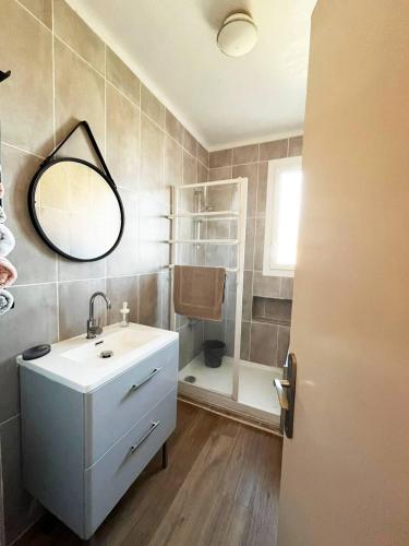 科利尤尔Merveilleux appartement style nature proche centre ville的浴室配有盥洗盆和带镜子的淋浴