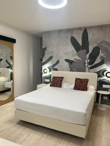里米尼阿索托丽亚套房酒店的卧室配有白色的床和植物墙