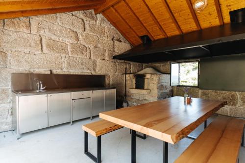 D'Autor Village的厨房配有木桌和石墙