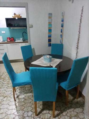 斯拉汀Apartmani Mislav的一间带桌子和蓝色椅子的用餐室