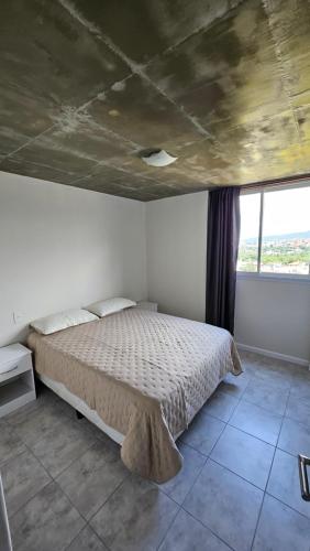 圣萨尔瓦多德朱El Mirador的一间卧室设有一张床和一个大窗户