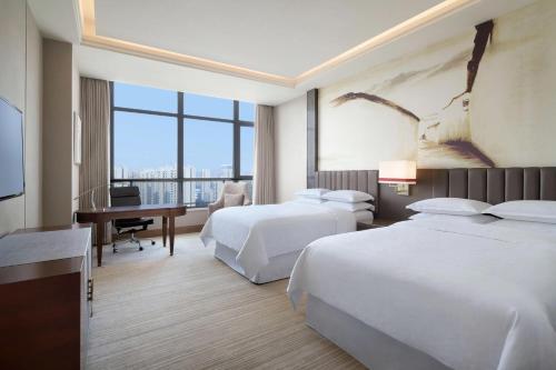 滁州滁州港汇喜来登酒店的酒店客房配有两张床和一张书桌