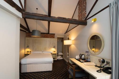 贝克尔斯The King's Head Hotel Wetherspoon的配有一张床和一张书桌的酒店客房