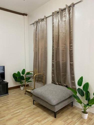 桑托斯将军城Balai ni Atan - relaxing studio unit near airport的客厅配有椅子和窗帘