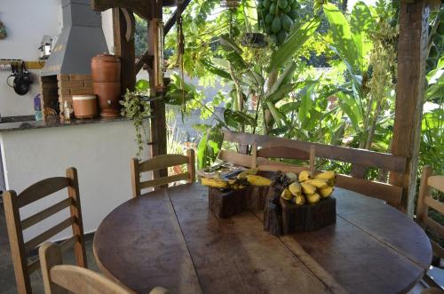 伊利亚贝拉Suítes Paquetá Ilhabela的一张木桌,上面放着一束香蕉