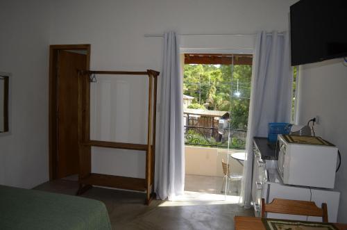 伊利亚贝拉Suítes Paquetá Ilhabela的卧室设有通往阳台的门