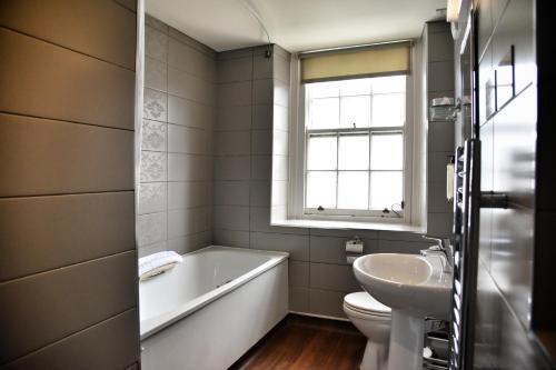 里辛维瑟斯普恩城堡酒店的带浴缸、盥洗盆和卫生间的浴室