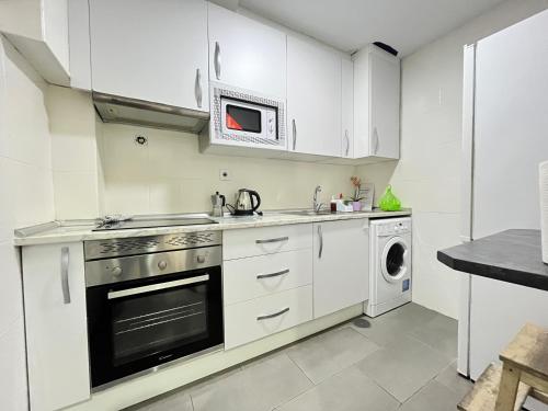 马德里Ile Aina Exterior Nuevo Peña的厨房配有白色橱柜、洗衣机和烘干机