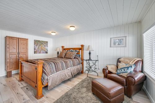 白鱼镇Lakeside Whitefish Cottage with Private Hot Tub!的一间卧室配有一张床和一把椅子