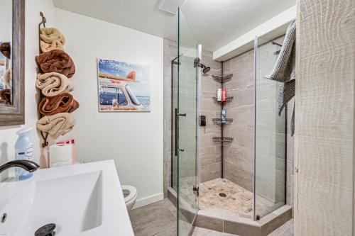 白鱼镇Lakeside Whitefish Cottage with Private Hot Tub!的带淋浴和玻璃淋浴间的浴室