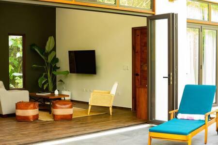 Benque Viejo del CarmenPrivate Modern Villa Near Resort District的客厅配有两把椅子和电视