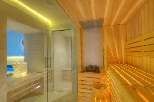 蒙特瓦尔基Dependance Villa Sassolini的浴室设有玻璃淋浴间和木墙