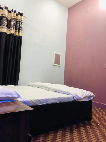 马图拉Krishna home inn.的一间卧室配有一张带黑色窗帘的床