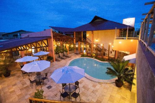 拉巴拉德纳圣米格尔薇瓦巴拉酒店的酒店设有一个游泳池、桌子和遮阳伞