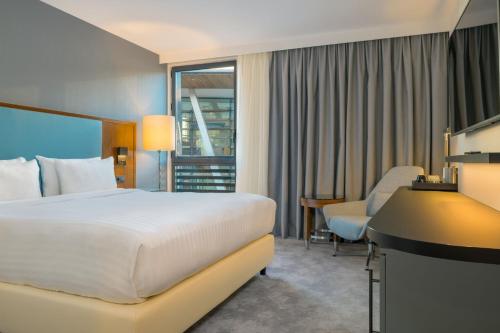 阿尔克伊万豪巴黎阿克伊度假酒店的配有一张床和一张书桌的酒店客房