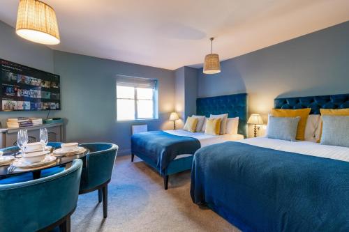 巴斯Silcox House Bath的酒店客房带两张床和一张桌子以及椅子。