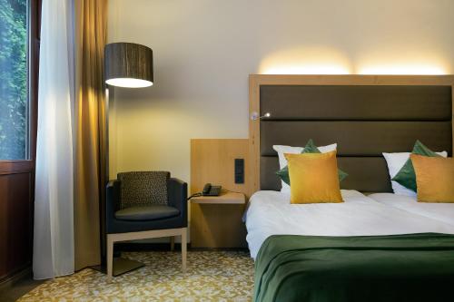 尼韦勒Hotel Restaurant Van Der Valk Nivelles-Sud的配有一张床和一把椅子的酒店客房