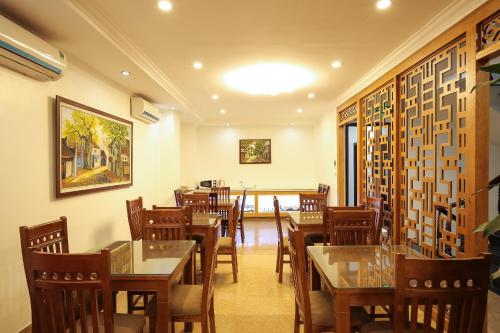 河内Khách Sạn 239的一间在房间内配有桌椅的餐厅