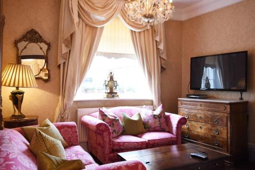 沃里克Warwick Centre Townhouse的客厅配有粉红色的沙发和窗户