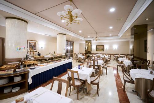 潘普洛纳阿尔伯雷特酒店的一间带桌椅的餐厅以及一间自助餐