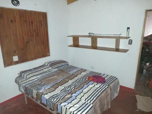 阿里斯托布罗德瓦里Alojamiento Aristobulo del valle Misiones的墙上架子的房间的一张床位