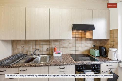苏黎世Urban Living Redefined: Apartment in Oerlikon的厨房配有水槽和台面