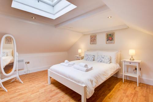 伦敦Wonderful Two-Bedroom Apartment的卧室配有白色的床和天窗