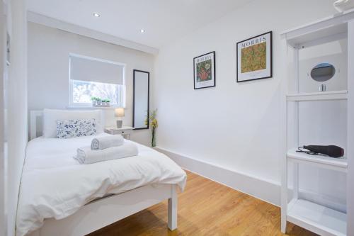 伦敦Wonderful Two-Bedroom Apartment的白色的卧室设有床和窗户