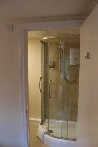 瓦伊河畔罗斯古德里奇宾馆的浴室里设有玻璃门淋浴