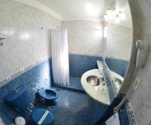 罗萨里奥Hotel Mayoral的一间带水槽、卫生间和镜子的浴室