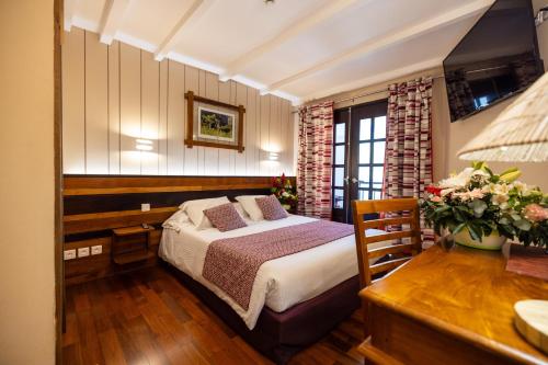 锡拉奥乐维克斯切普酒店的一间卧室配有一张床、一张桌子和一张书桌