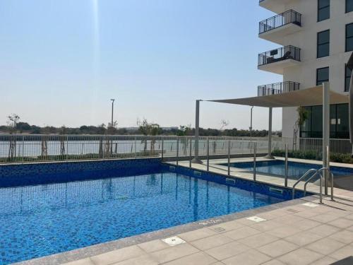 阿布扎比2 bedroom apartment Wabi Sabi in Yas的大楼旁的大型游泳池