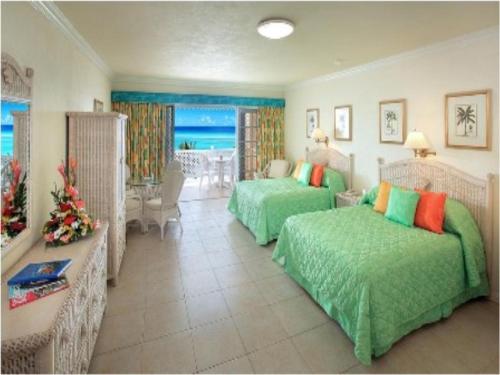 布里奇敦珊瑚沙滩度假酒店的一间带两张床的卧室和一间客厅