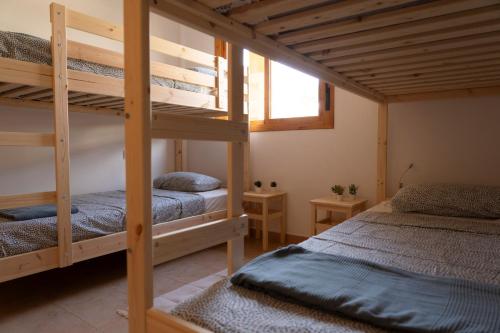 奇克拉纳－德拉弗龙特拉Namawa Surfhouse的一间卧室设有两张双层床和一扇窗户。