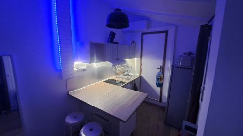 土伦Ancien appartement de pêcheur的一间带水槽和蓝色灯光的浴室