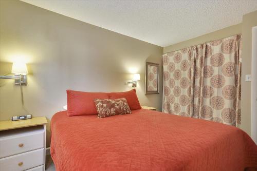 布雷肯里奇Tannhauser 225的一间卧室配有一张红色棉被的床