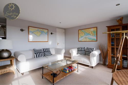 利明顿Leeward House - Luxury, Spacious, Sea View Apartment, Parking, Central Lymington的客厅配有2张白色沙发和1张桌子
