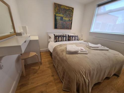 卢顿Neon Heights 2 bed Luton town centre的一间卧室配有一张床,上面有两条毛巾