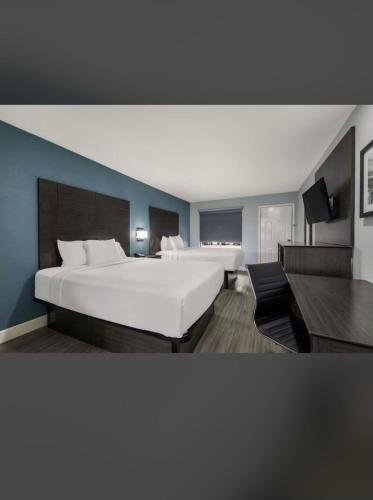 圣安东尼奥Rodeway Inn San Antonio Downtown的卧室配有白色大床和蓝色的墙壁