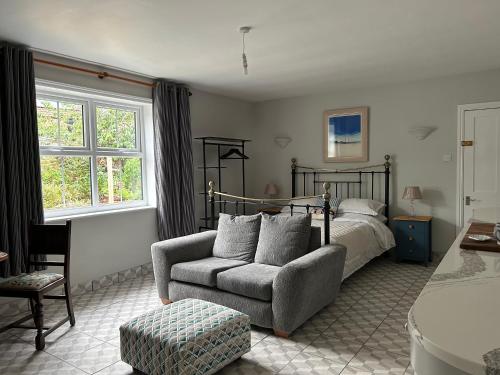 CaistorCaistor Bed & Breakfast的一间卧室配有一张床、一张沙发和一把椅子