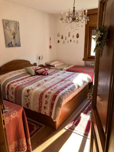 科尔蒂纳丹佩佐Ciasa Nonna Bon Bon的一间卧室配有两张床和吊灯。