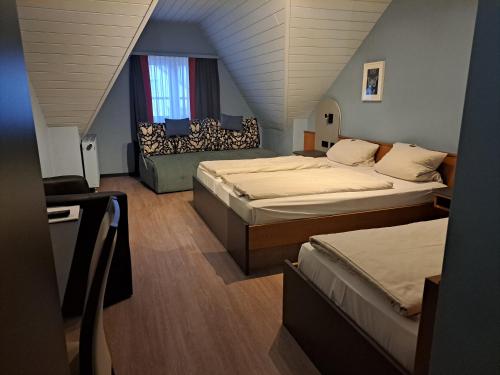 特里芬Gasthaus Sonne GbR的阁楼卧室配有两张床和一张沙发