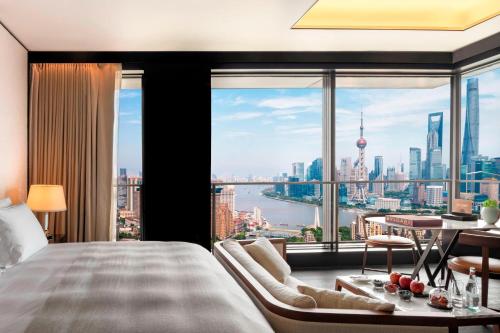 上海上海宝格丽酒店的卧室设有大窗户,享有城市美景。