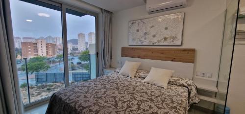 菲内斯特拉特APARTAMENTOS OASIS DE LA CALA的一间卧室设有一张床和一个大窗户
