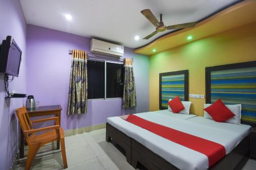 杜尔加布尔Hotel Kohinoor的一间卧室配有一张床、一台电视和一把椅子