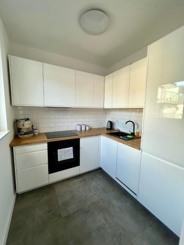 科沙林Apartament Studio Centrum的一间空厨房,配有白色橱柜和水槽